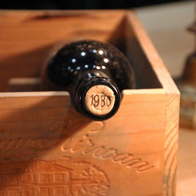 A bottle of 1980 Château Kirwan 1855 Grand Cru Classé sits in a wine box