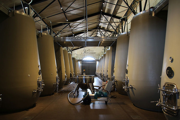 Inside the winery with large concrete tanks used to ferment the wine at Château Kirwan