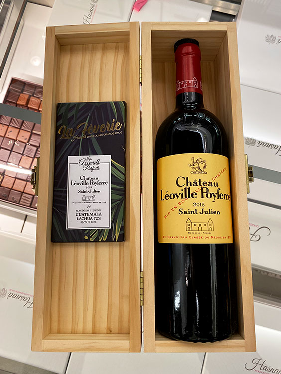 The new collaboration between Château Léoville-Poyferré and Hasnaâ Chocolats Grands Crus with a bottle of 2015 and two chocolate bars in a wooden keepsake box
