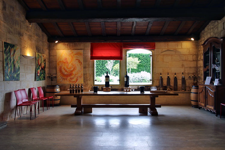 The former vat house is now the tasting room with some artworks displayed, large glass vases with the terroir of each vineyard and some bottles of wine displayed