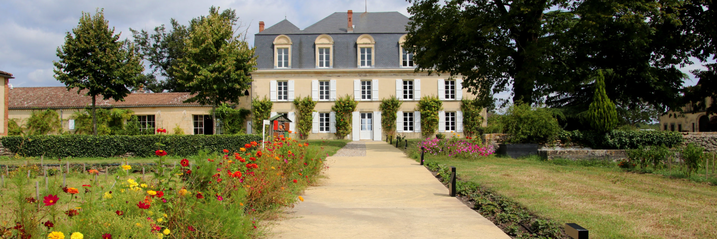 A long paved walkway leads to the main chateau and is lined with beds of marigolds