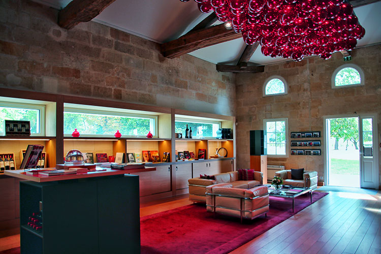 A massive red glass chandelier dominates the boutique to look like a bunch of grapes hanging from the ceiling at Chateau La Dominique