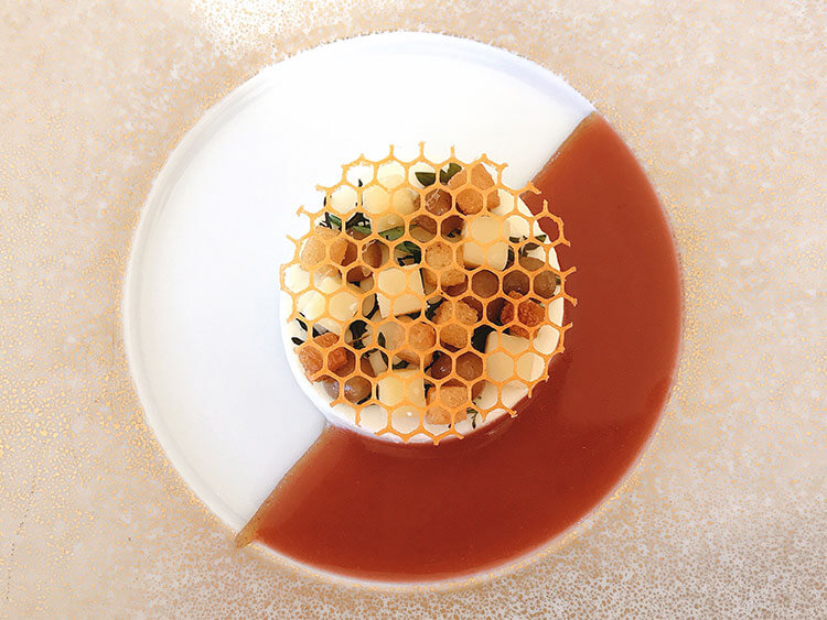 Comté cheese cut into small cubes with herbs and citrus fruit, then topped with a lattice made to look like a honeycomb at Restaurant Lalique at Chateau Lafaurie Peyraguey