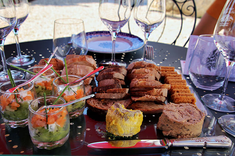 Salmon with kiwi in little glass jars and a platter of breads with foie gras and rillette