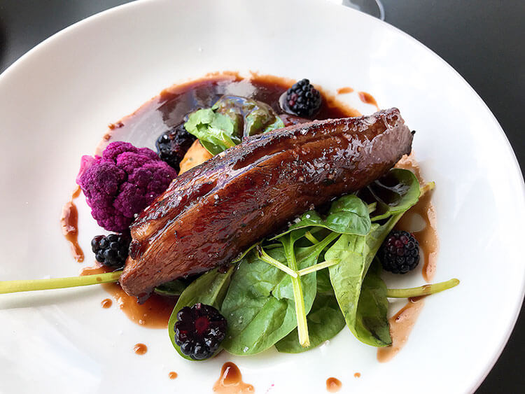 Duck breat on a bed of greens with purple cauliflower and balckberries at La Terrasse Rouge
