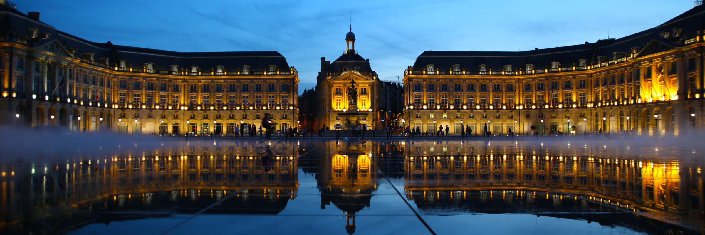 Blue hour at Bordeaux's Water Mirror with the mirror-like surface after the water drains and the mist starting to come on as the Place de la Borse is light up and reflects on the mirror