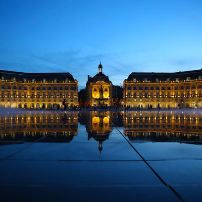 Blue hour at Bordeaux's Water Mirror with the mirror-like surface after the water drains and the mist starting to come on as the Place de la Borse is light up and reflects on the mirror