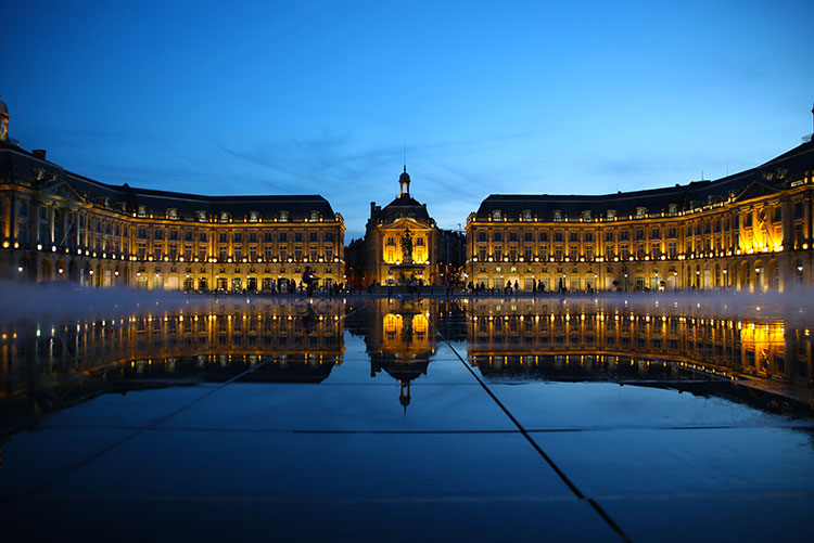 Blue hour at Bordeaux's Water Mirror with the mirror-like surface after the water drains and the mist starting to come on as the Place de la Borse is light up and reflects on the mirror