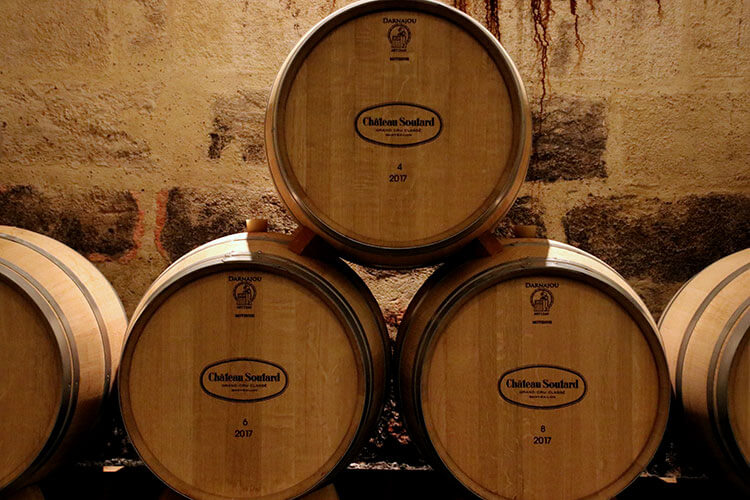 A small stack of barrels are in a reception room at Château Soutard