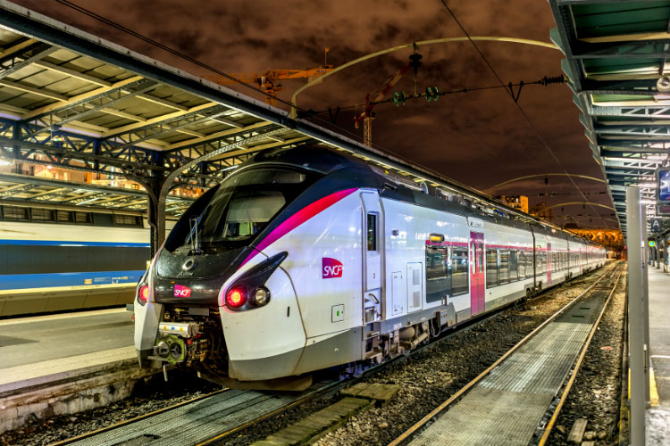 A SNCF TGV train is parked at a platform in a train station