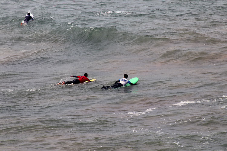 Instructor and student paddle out side by side on the Plage de la Côtes des Basques