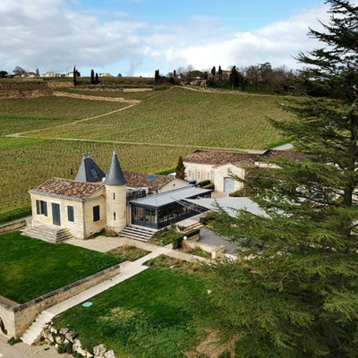 The little castle of Château de Candale with its turrets and surrounded by vineyards as seen from a drone aerial