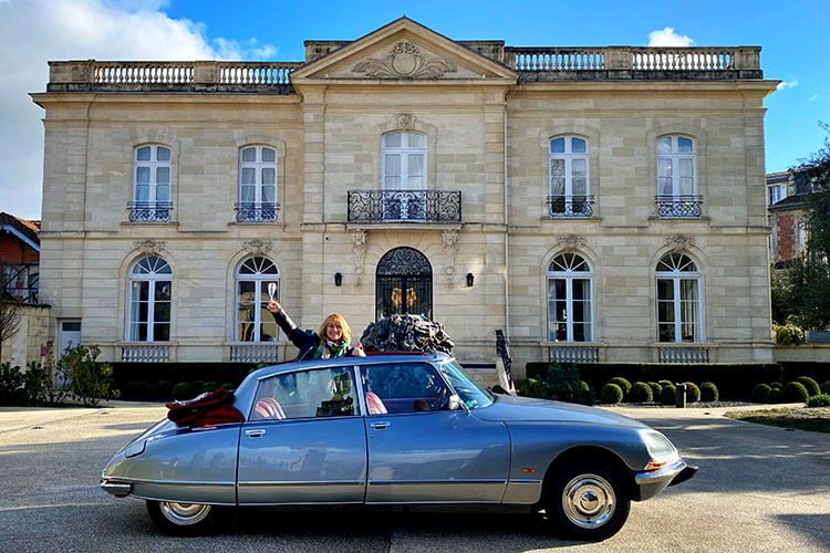 Jennifer poses in the Citroën DS with a glass of champagne and the top down in Bordeaux, France