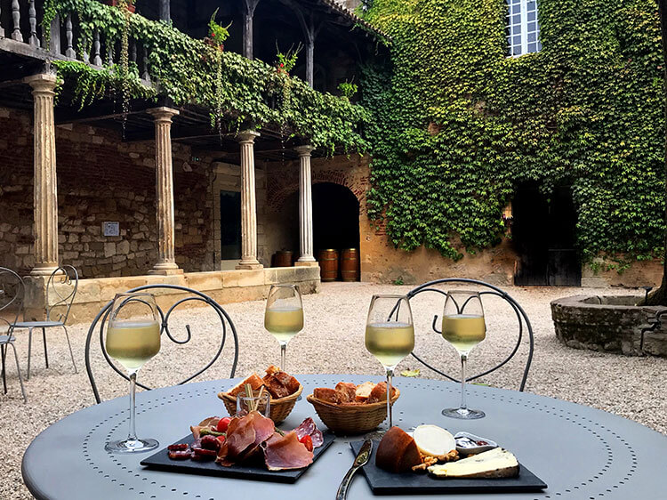 The 17th century Cloître des Récollets with tables for enjoying the wine bar offerings of the Quai Cyrano in Bergerac