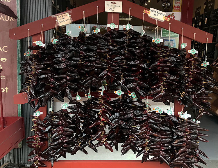 Strings of dried Espelette peppers hang from a rack