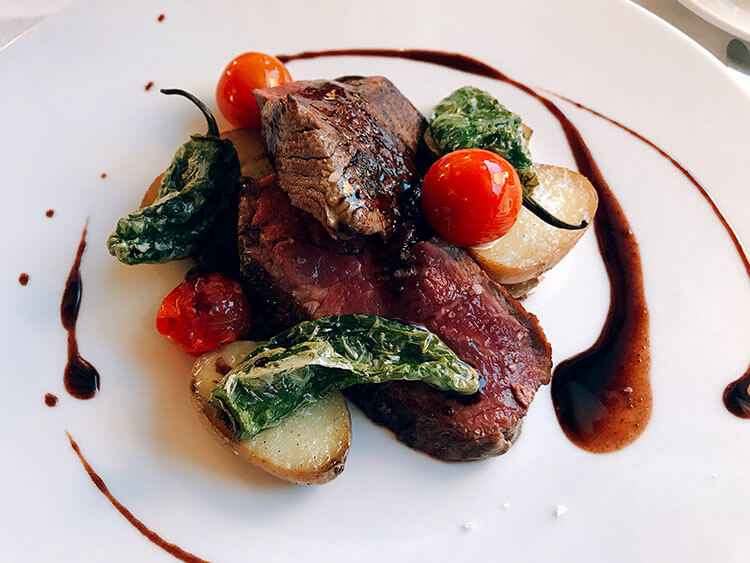 Filet of beef with cherry tomatoes, blistered Padrón peppers and potatoes at Hotel Arraya