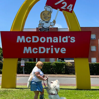 Jennifer and Coco high five in front of the vintage McDonald's Drive sign at the McDonald's V-O in Villenave-d'Ornon