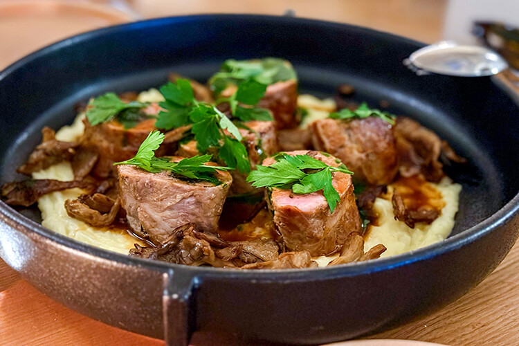 Veal stuffed with mushrooms on a bed of mashed potatoes and served in a cast iron pan at OST Restaurant