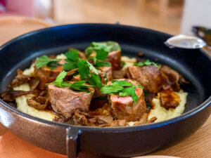 Veal stuffed with mushrooms on a bed of mashed potatoes and served in a cast iron pan at OST Restaurant
