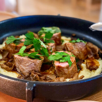 Veal stuffed with mushrooms on a bed of mashed potatoes and served in a cast iron pan at OST Restaurant