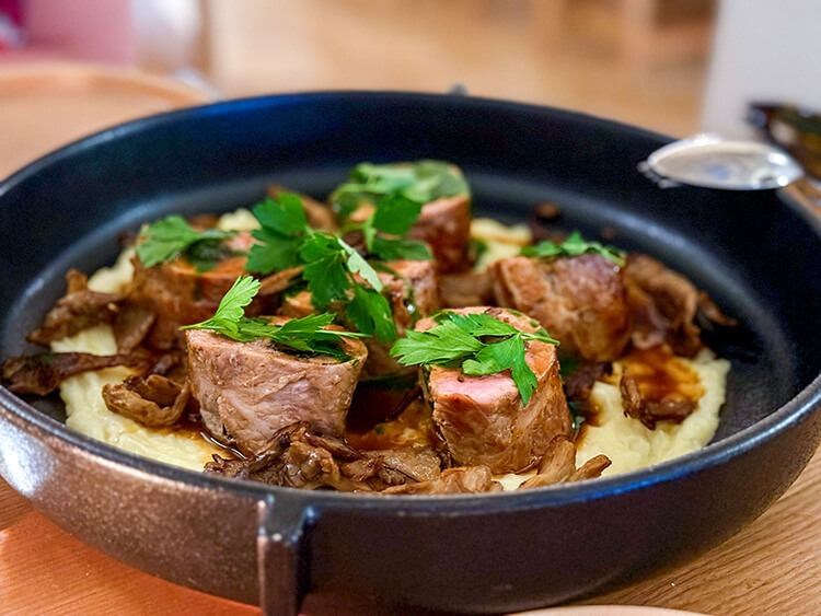 Veal stuffed with mushrooms on a bed of mashed potatoes and served in a cast iron pan at OST Restaurant