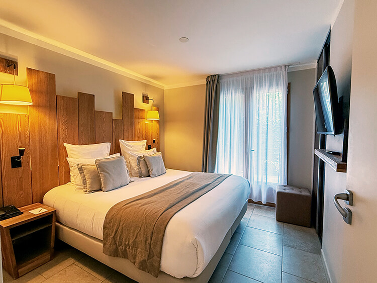 A Superior Lodge 1 Bedroom with queen bed and neurtral colored bedding at Domaine du Ferret in Claouey, Lège-Cap-Ferret, France