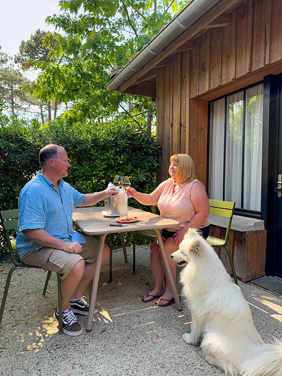 Jennifer, Tim and Coco sit on the terrace enjoying an apero at Domaine du Ferret, Claouey, Lège-Cap-Ferret, France 