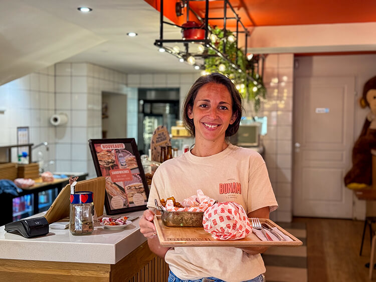 Bunami co-founder Manon holds a platter with her signature pulled pork and side of potatoes at Bunami