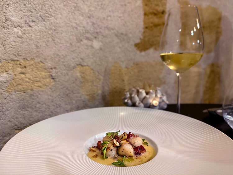 Scallops in white butter sauce paired with a glass of white Bordeaux at INIMA