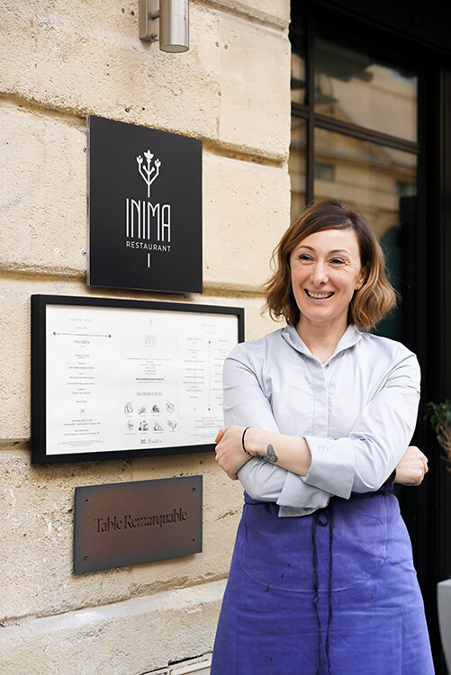 Chef Oxana Cretú proudly stands outside her restaurant, INIMA