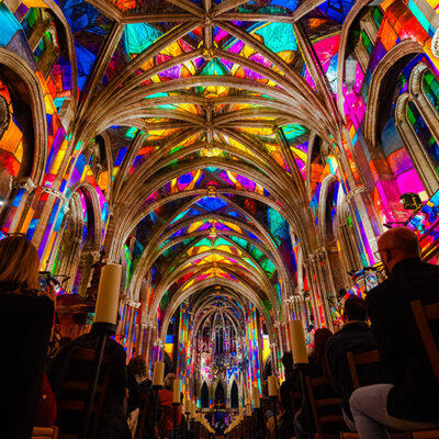 Ceiling and nave of Cathedral Saint-André in a rainbow of bright colors like pinks, yellows, and greens during LUMINISCENCE Bordeaux