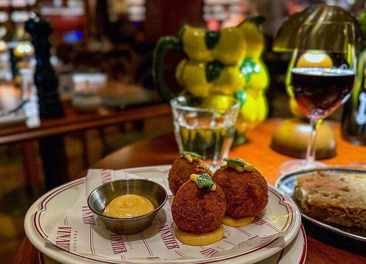 Three lamb croquettes topped with an herb and served with piri-piri mayo at Brasserie Vinatier