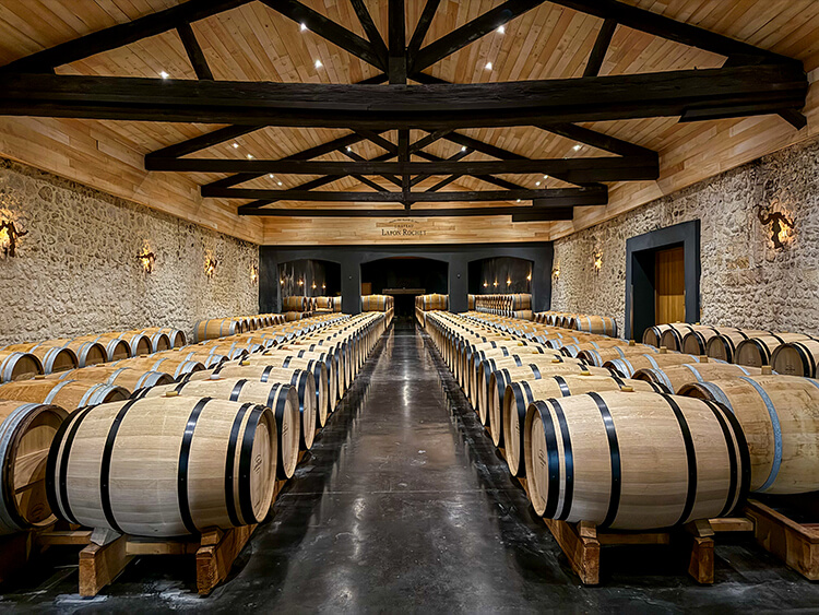 A large fireplace is a unique fixture, of course never used, in the second barrel room at Château Lafon-Rochet