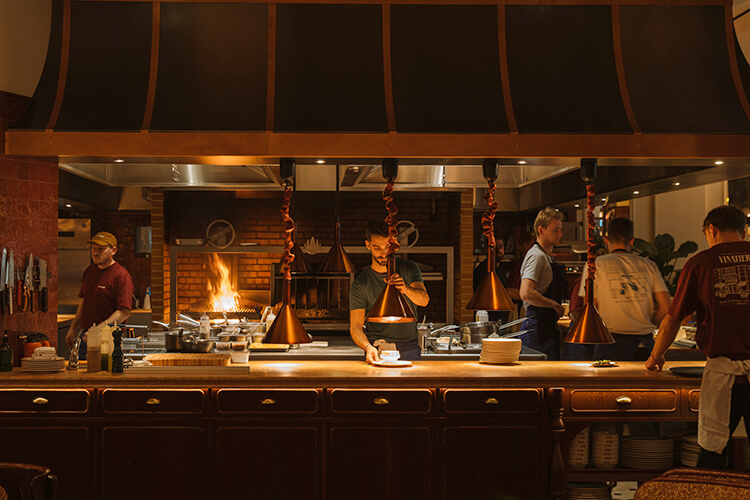 Chefs work to prepare onion soup in the open kitchen at Brasserie Vinatier